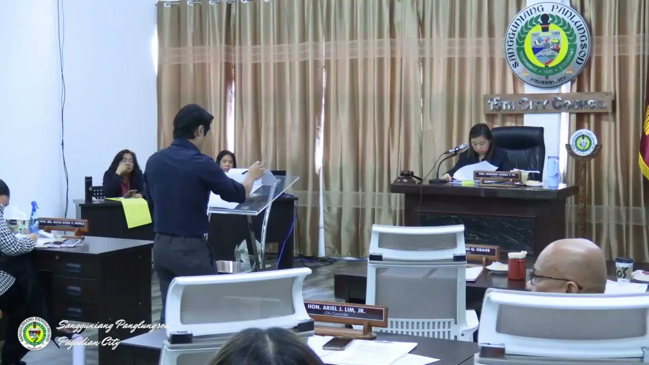 A council member presents a committee report at the podium during the 46th Regular Session, with the Vice Mayor presiding.